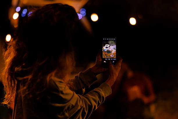 istock Capturing a moment with a smartphone during a nighttime gathering under fairy lights 2239843720