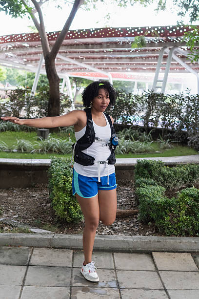 Woman warming up, doing quad stretch, preparing for her run