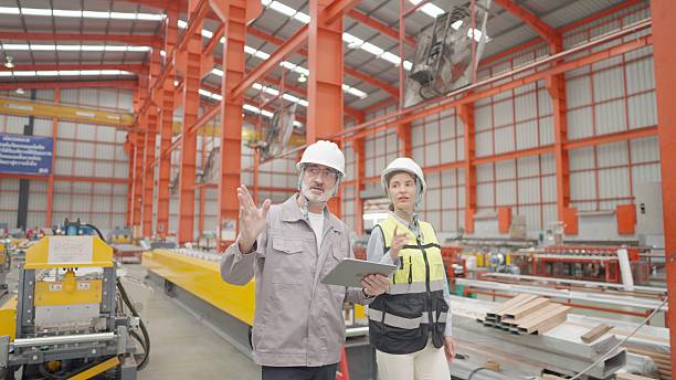 istock Industrial factory workers operating control the production system on the assembly line at production plant. Engineers supervising production flow to enhance productivity and maintain workplace safety standards. 2239854256