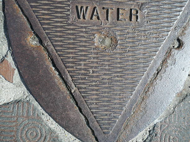 istock Weathered metal water utility cover in ground with triangle shape 2239855987