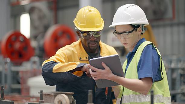 istock Factory engineers and production staff wear safety uniforms and helmets while operating heavy machinery, ensuring smooth and efficient manufacturing processes inside the industrial plant. Worker working at production line in steel manufacturing factory. 2239856767