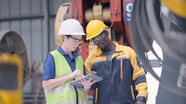 istock Industrial plant engineers discuss process improvements, reviewing workflow charts and suggesting automation upgrades for better production efficiency. Engineer or technician , wear safety uniform and hard hats, controlling at steel machine in industry. 2239856778