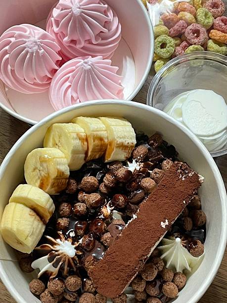 Swirled yogurt ice cream dessert served in a cup, smooth creamy texture with glossy surface, topped with fresh fruit pieces, highlighting its refreshing and inviting appearance in detail