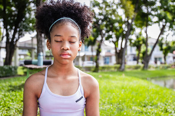 istock Girl athlete meditating outdoors in park with eyes closed peaceful expression 2239864267