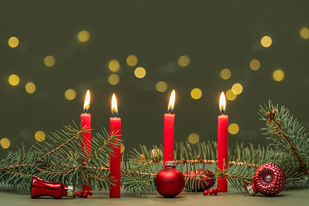 istock Four red burning candles, Christmas tree balls, and spruce branches on a green background with bokeh. Christmas background, greeting card. 2239865383