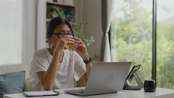 istock Asian Woman Drinking Tea While Working at Home.4k 2239872460