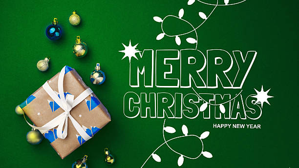 istock Festive Christmas gift with colorful decorations on a green background 2239873576