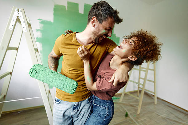 istock Cheerful couple having fun while painting their new home. 2239874252