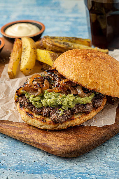 istock Smash burger with cheddar cheese and caramelized onions, served with fries 2239875564