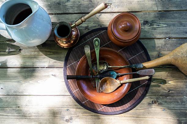 This image showcases an idyllic scene of traditional kitchen utensils arranged on weathered wood, evoking feelings of nostalgia and simple living