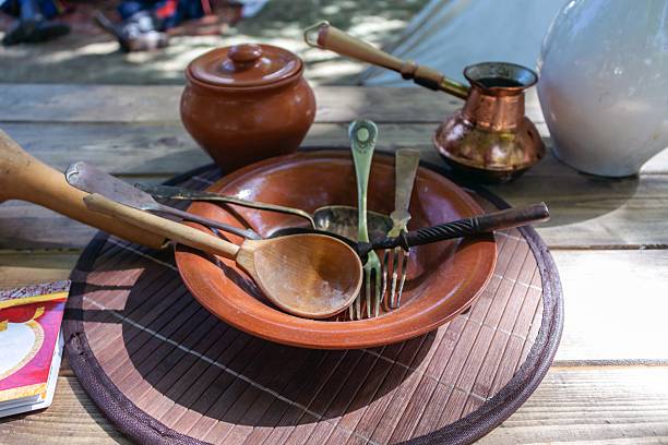 This image showcases traditional pottery and rustic cutlery arranged for an authentic medieval dining experience, highlighting cultural heritage