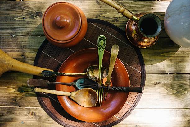 Authentic kitchen scene showcasing handcrafted ceramic bowls, plates, jugs, and spoons, perfect for conveying a sense of heritage and natural simplicity