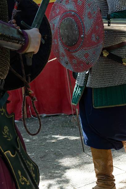 Reenactment of medieval battle with knights in chainmail armor, historic european martial arts, traditional warfare equipment close up view