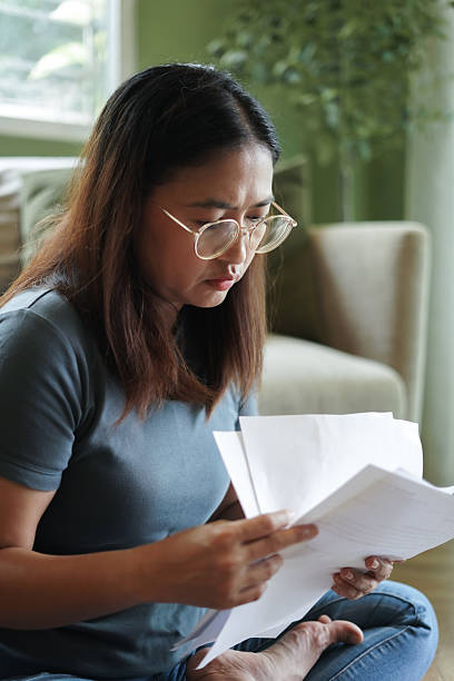 istock Woman checking financial papers at home 2239880336