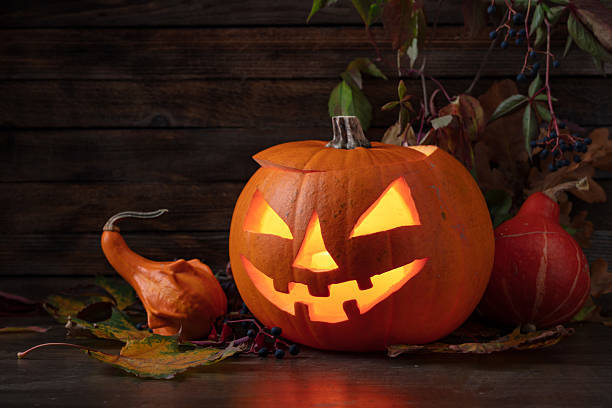 istock Halloween pumpkin head jack lantern with dried-up leaves. 2239881019