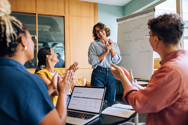 istock Team members applaud a woman leading a presentation in an office setting 2239881202