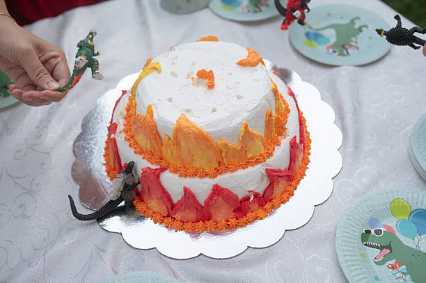 Creative Fire Themed Cake With Toy Dinosaurs For Birthday Festivity