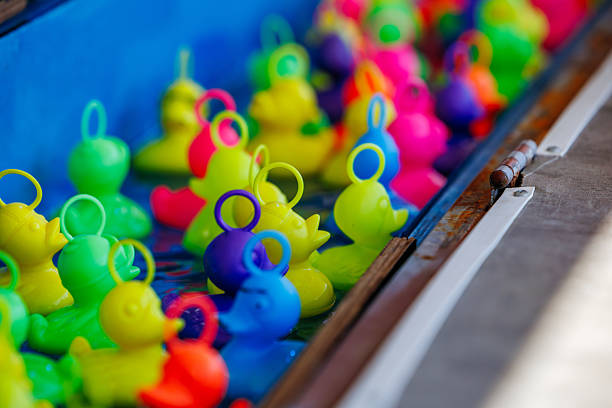 istock Colorful rubber ducks floating in a vibrant blue water basin at a carnival game 2239884957