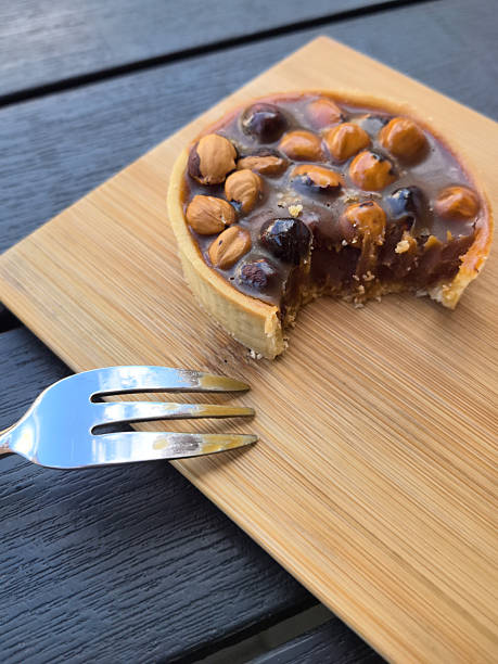 Delightful dessert experience with a nutty tart and fork on wooden surface