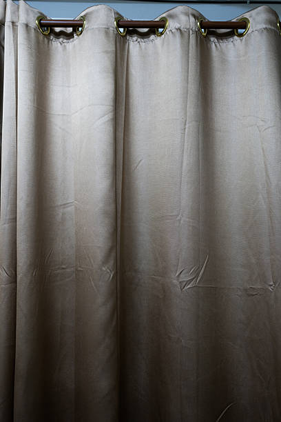 istock Brown curtains hanging on a wooden rod. 2239891747