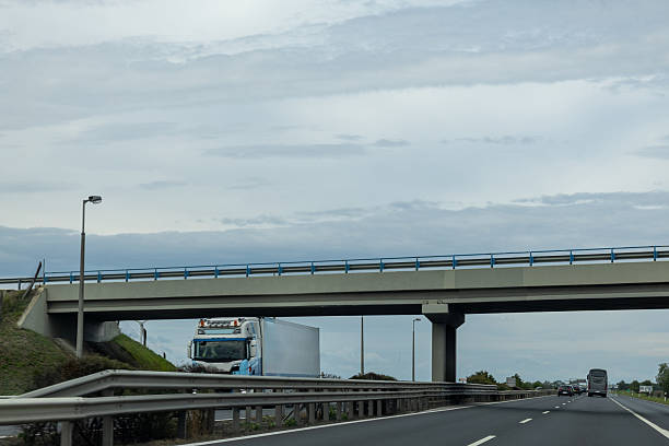istock Truck approaching on highway under overpass 2239893581