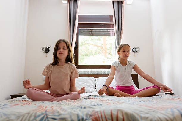 istock Two girls meditating on a bed 2239893772