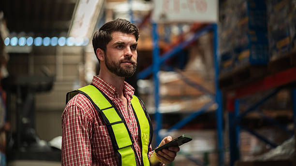 istock Warehouse worker working and checking the stock in the warehouse. Factory manager using digital tablet check barcode in industry factory logistic. 2239893981