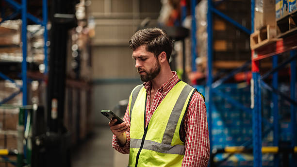 Warehouse worker working and checking the stock in the warehouse. Factory manager using digital tablet check barcode in industry factory logistic.