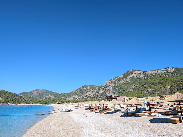 istock Scenic Beachfront View with Lounge Chairs and Mountains 2239895907