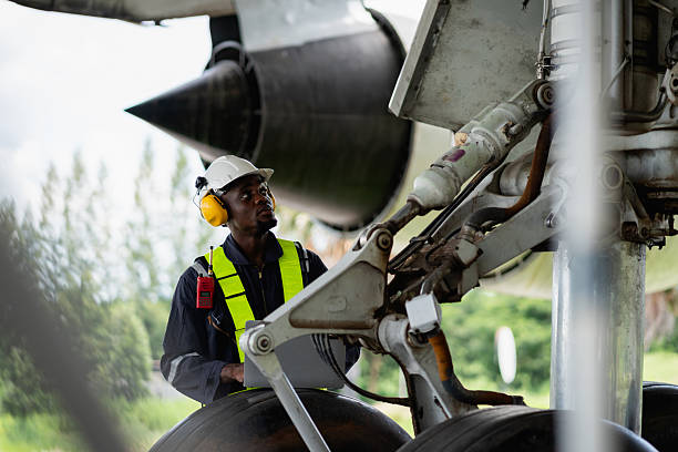 Aircraft maintenance engineer inspecting airplane engine with safety equipment and tools, aviation mechanic ensuring aircraft repair, safety check, and technical engineering service.