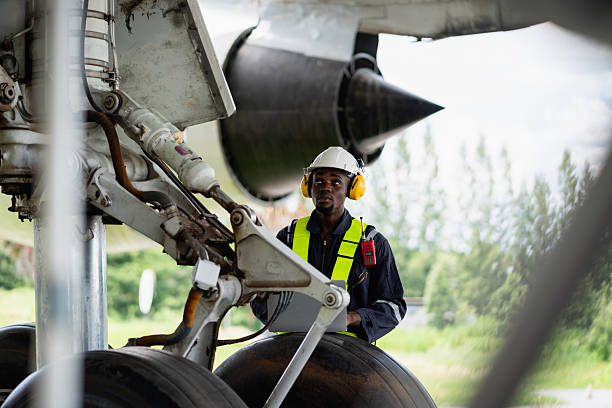 Aircraft maintenance engineer inspecting airplane engine with safety equipment and tools, aviation mechanic ensuring aircraft repair, safety check, and technical engineering service.