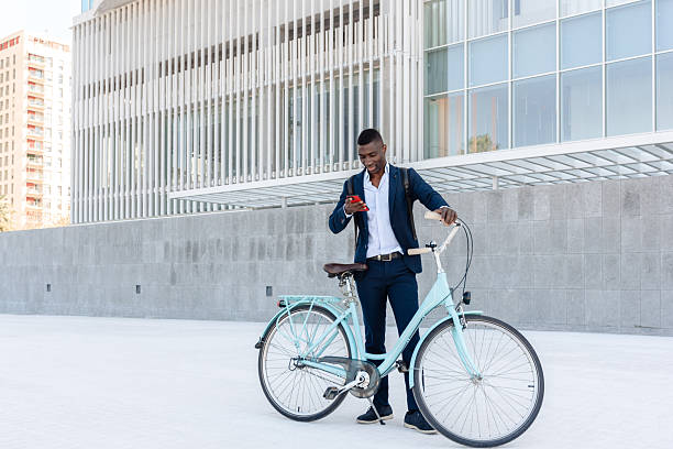 istock African american entrepreneur using smartphone while holding bicycle outside office 2239899678