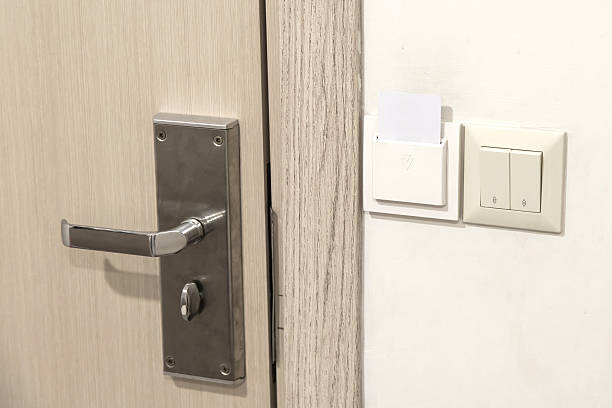 istock Metal door handle next to hotel key card power switch and light controls on a beige wall. scene represents modern hotel technology and energy-saving systems used for guest convenience and efficiency. 2239900861