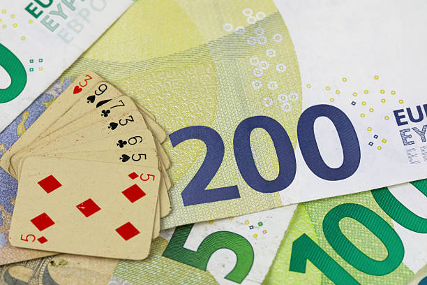 This is the currency of the European Union. The playing cards are partially covering the banknotes because they have been piled on top of them. This theme can represent gambling and finance.