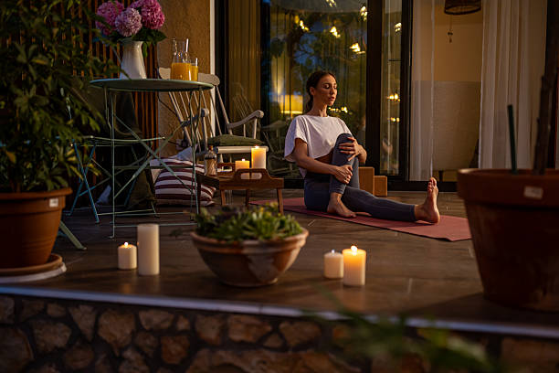 istock Young Woman Practicing Yoga on a Cozy Patio at Night 2239905776