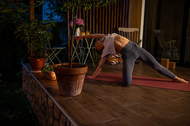 istock Young Woman Practicing Yoga on Outdoor Deck at Dusk 2239905862