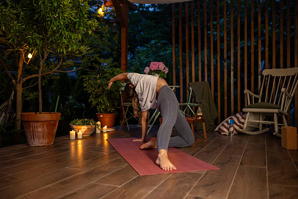 istock Woman Practicing Yoga Outdoors at Night in a Cozy Patio Setting 2239905882