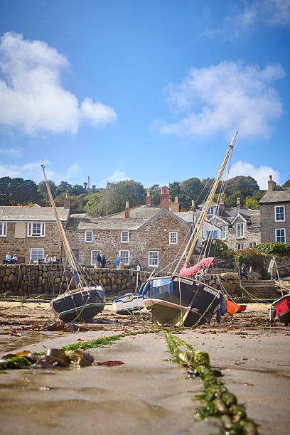 Mousehole Harbour an village at low tide, Cornwall, England, UK during a sunny day