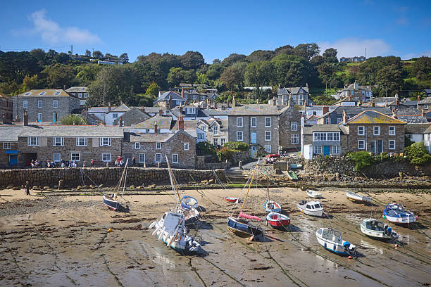 Mousehole Harbour an village at low tide, Cornwall, England, UK during a sunny day