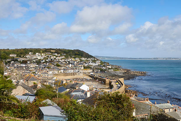 Mousehole Harbour an village at low tide, Cornwall, England, UK during a sunny day