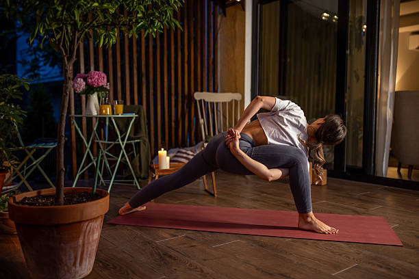 Woman Practicing Yoga in a Serene Indoor Setting At Night