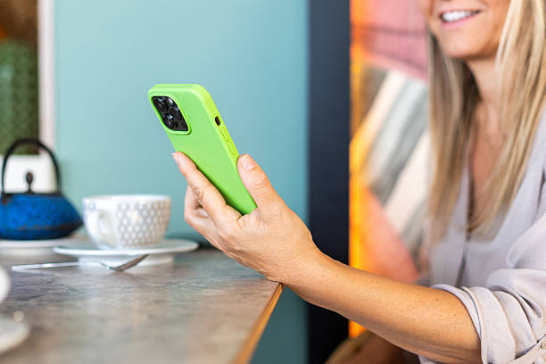 istock Woman smiling using smartphone having coffee in cafe 2239906318