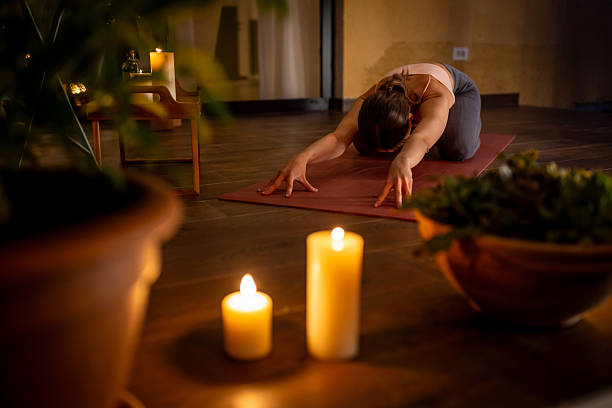 Woman Practicing Relaxing Yoga by Candlelight in a Serene Home Setting