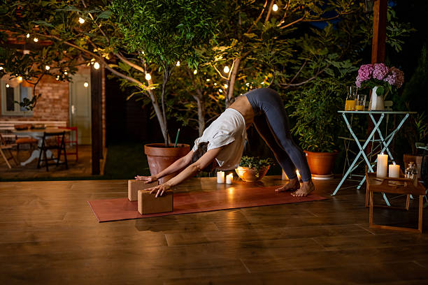istock Woman Practicing Yoga Outdoors on a Peaceful Evening with String Lights 2239907967