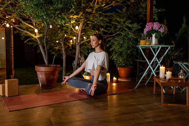 istock Woman Practicing Meditation Outdoors by Candlelight in a Peaceful Garden Setting 2239908133