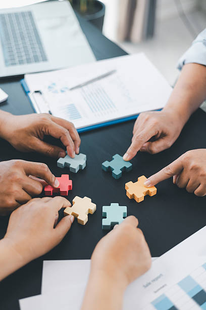 Business teamwork concept with people holding wooden puzzle pieces together, symbol of collaboration, strategy, problem solving, partnership and corporate success in modern office. business teamwork.