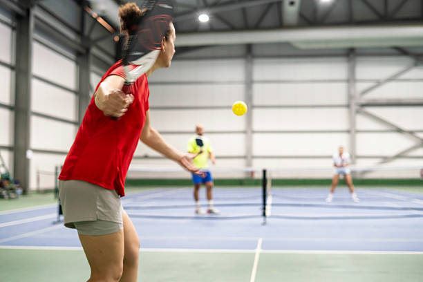 istock female pickleball player is shooting servis with motion blur on foreground double player are background horizontal pickleball still 2239912444