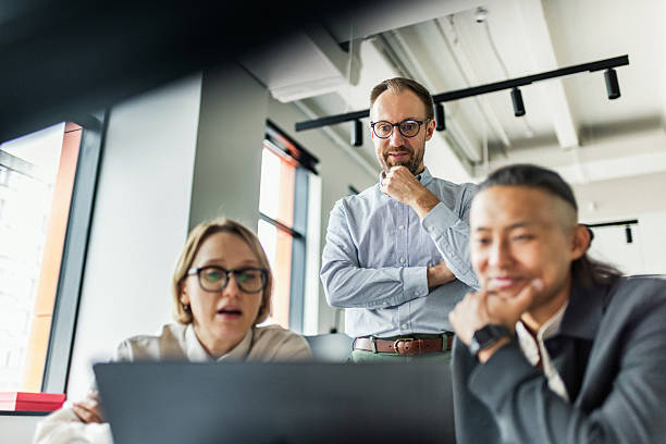 istock Three professionals collaborate around a laptop in a bright office, sharing ideas and planning a project together. 2239914395