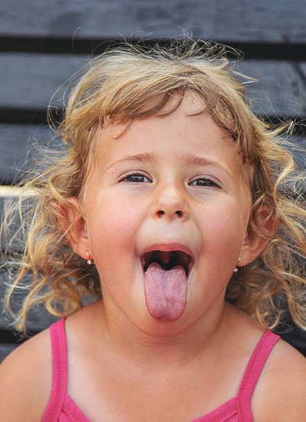 Child sticking out tongue. Selective focus. nature.
