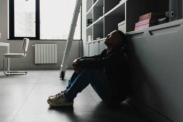 istock Exhausted office worker resting on the floor by cabinets after a long day in a modern workspace 2239914785